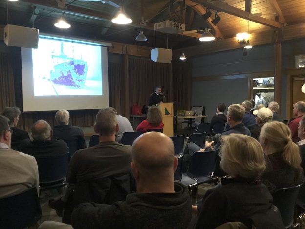 Audience listens to a speaker with screen projection in the Winter Speaker Series