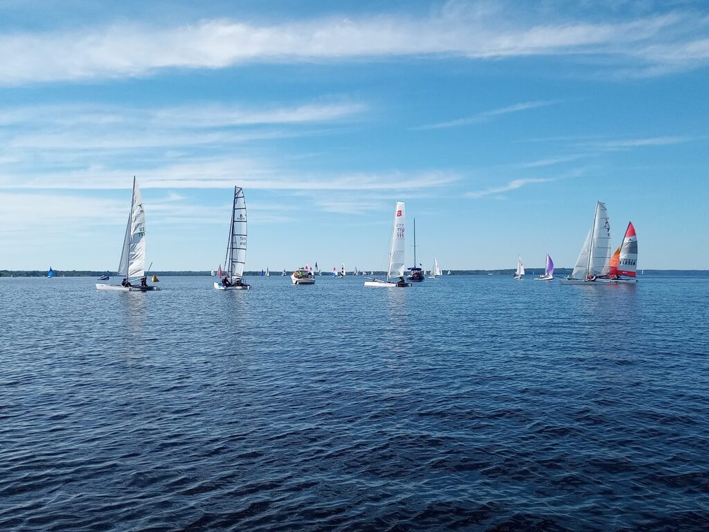 Catamarans near the race committee boat preparing to start