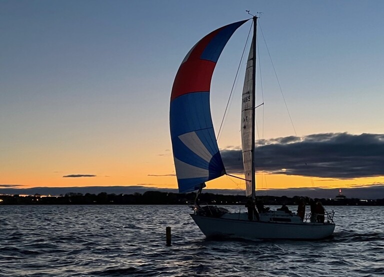 Sailboat flying a spinnaker at sunset